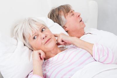 woman awake due to her husband's snoring