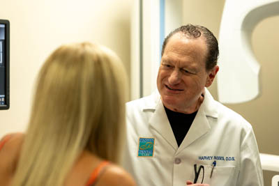 Dr. Harvey Passes speaking with a dental implant patient