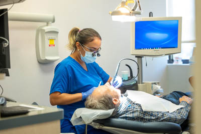 dental assistant helping conduct preventive care on a patient